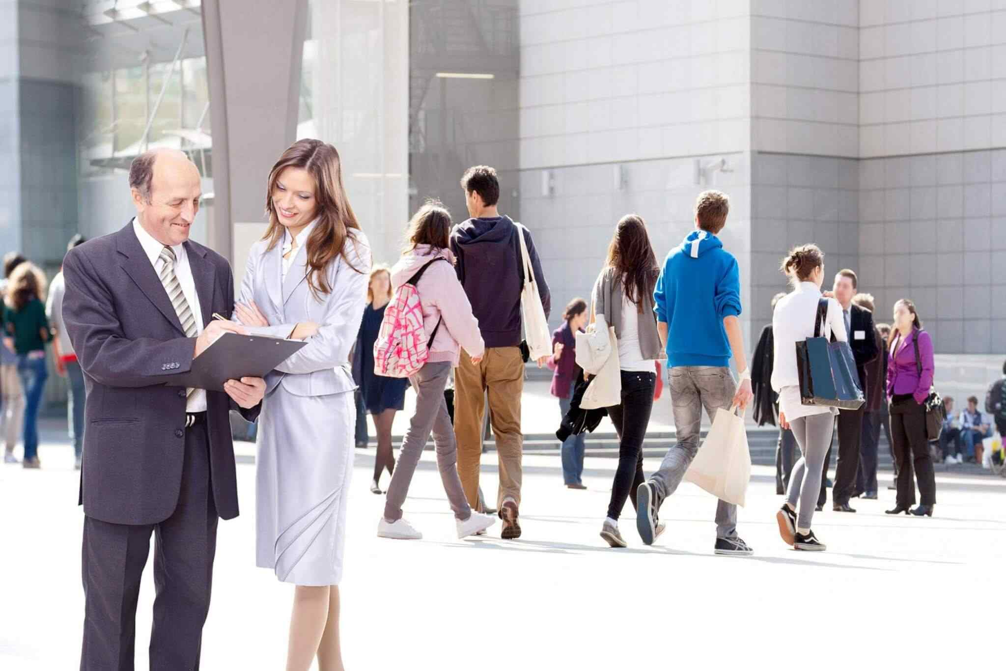 People interacting outside modern building.