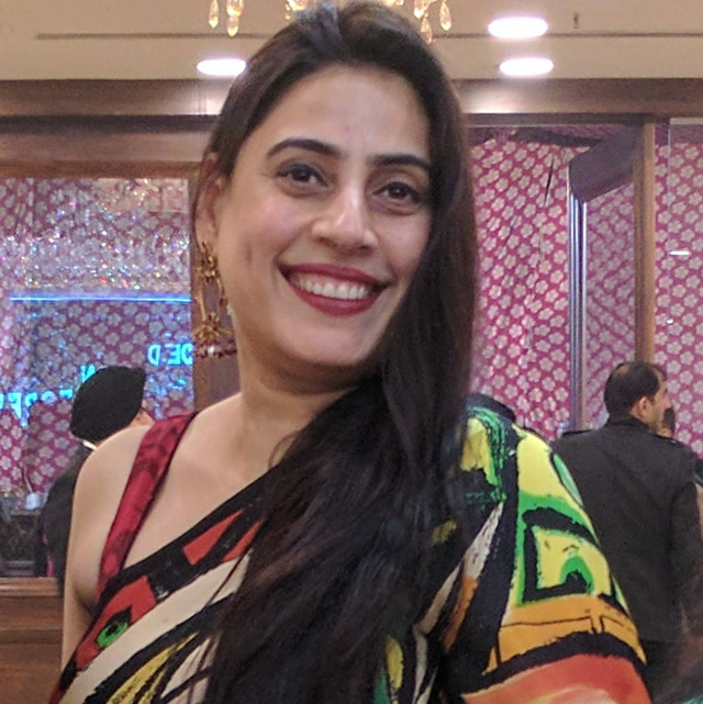 Smiling woman in colorful patterned attire.