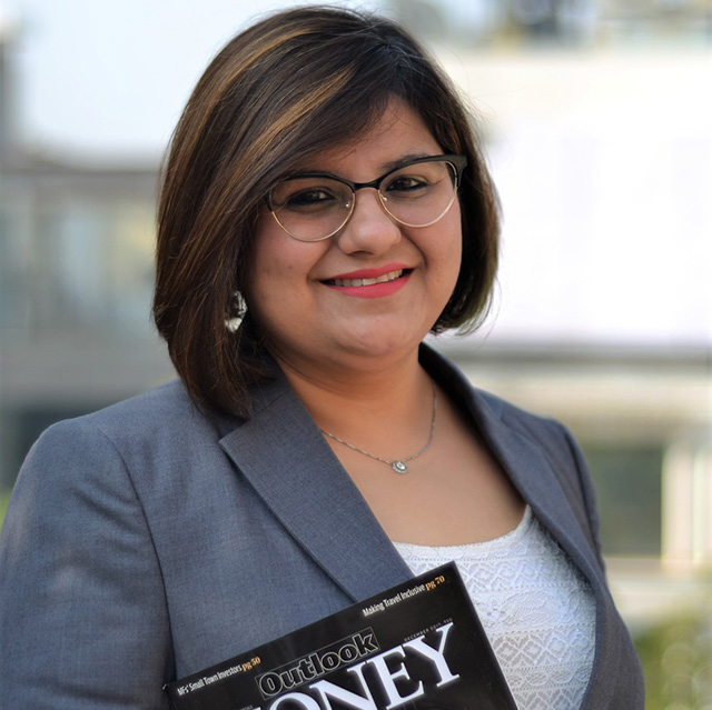 Smiling woman holding a magazine outdoors.