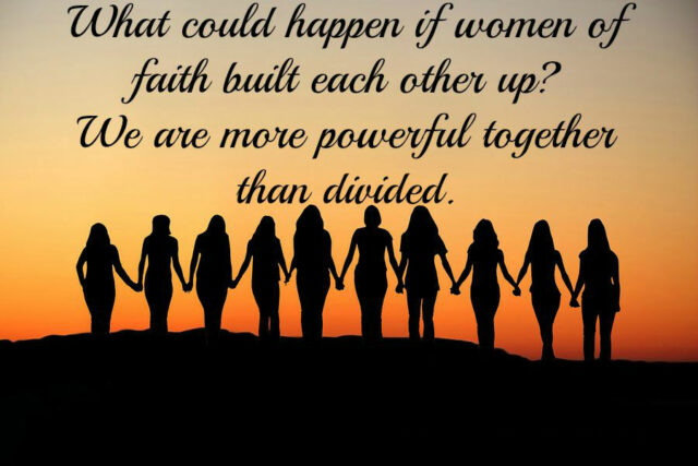 Silhouettes of women holding hands at sunset.