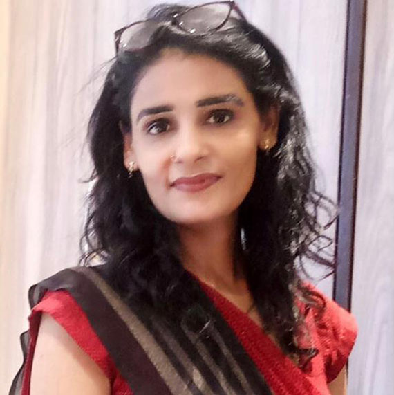 Woman wearing glasses and red outfit smiling.