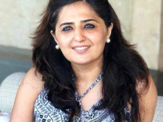 Smiling woman with long hair and earrings.